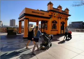  ??  ?? In this Jan. 17 file photo, visitors walk past Angels Flight Railway in Los Angeles. The tiny funicular that hauled people 298 feet up and down the city’s steep Bunker Hill was shut down in 2013 after a series of safety problems. At a news conference...
