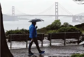  ?? Benjamin Fanjoy/The Chronicle ?? David Julian walks in the rain in February at Lands End in San Francisco. Dry weather is likely throughout California for the next week to 10 days, however.