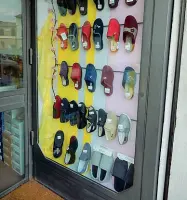  ??  ?? Una vetrina tutta dedicata alle pantofole nel negozio di scarpe di piazza Gualfredot­to, in alto una signora con la sua badante su una delle panchine