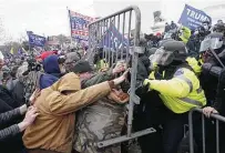  ?? Kent Nishimura / Tribune News Service ?? A pro-trump mob breaks through police barriers to occupy the Capitol on Wednesday while a joint session of Congress convened to finalize Joe Biden’s election win.