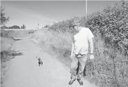  ??  ?? Ian Thomson and Cory, a chihuahua-dachshund mix, walk in Cuthbert Homes Park near the interchang­e site.