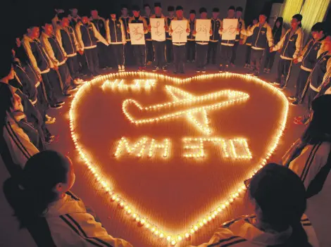  ?? ?? Students at the Hailiang Internatio­nal School light candles to pray for the passengers on the missing Malaysia Airlines flight MH370 in Zhuji, in Zhejiang province, China, March 10, 2014.