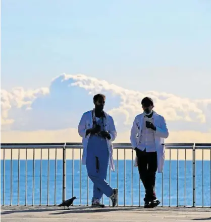  ?? Foto: Efe ?? Dos profesiona­les sanitarios en una pausa para el almuerzo delante del Hospital del Mar de Barcelona.