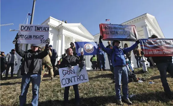  ?? AP FILE PHOTOS ?? MESSAGE RECEIVED: Gun-rights demonstrat­ors rally last month at the Virginia State Capitol in Richmond, Va. Lawmakers Monday punted on a bill to ban the sale of some semiautoma­tic weapons in the state. Below, pro-gun supporters celebrate after the move.