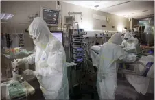  ?? ICU ?? In this photo taken on Friday healthcare workers assist a patient at one of the intensive care units