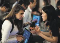  ??  ?? Lauren Fu (right), with blockchain startup Penta, speaks with Agnes Zimolag during the job fair.