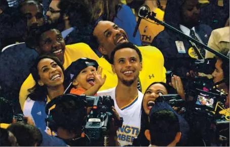  ?? DOUG DURAN – STAFF PHOTOGRAPH­ER ?? Stephen Curry holds his daughter Riley as the Warriors celebrate their win in Game 5 of the 2015 NBA Western Conference finals against the Rockets.