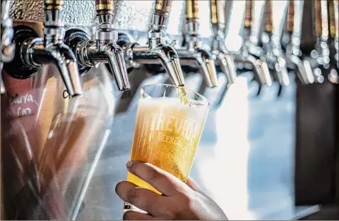  ?? Photos by Chet Strange / For The Washington Post ?? Kassy Fierro pours a beer at Atrevida Beer Co.