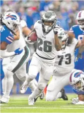  ?? ADRIAN KRAUS/AP ?? Eagles rookie running back Miles Sanders breaks through the Bills’ defense to score one of the Eagles’ three rushing touchdowns.