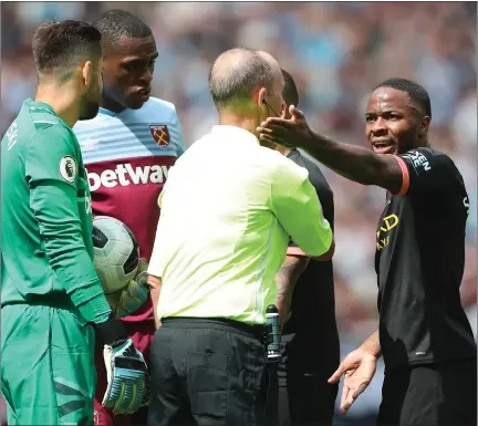  ??  ?? Manchester City players confront referee Mike Dean after a VAR decision leads to Raheem Sterling’s goal being disallowed