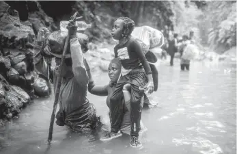  ?? AP ?? Haitian migrants wade through water as they cross the Darien Gap from Colombia to Panama in hopes of reaching the United States of America.