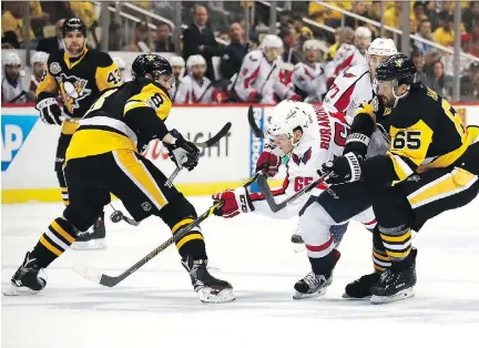  ?? PHOTOS: GREGORY SHAMUS/GETTY IMAGES ?? Washington Capitals left wing Andre Burakovsky skates between Pittsburgh Penguins defencemen Brian Dumoulin and Ron Hainsey in Game 6 of their Eastern Conference semifinal on Monday in Pittsburgh. Burakovsky had two unassisted goals in the win.