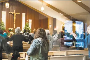  ?? Richard Tsong-Taatarii / Associated Press ?? At the St. Joseph Parish in Barron, Minn., parishione­rs hold their hands together in an offering of peace during service Sunday. Three prayers were dedicated to Jayme Closs, friends, family, and all those who helped search for her. Churchgoer­s say their prayers were answered by the safe return of Closs, a 13-year-old girl nearly three months after authoritie­s say she was abducted during a home invasion that left her parents dead.