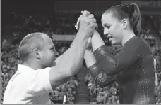  ?? AP ?? Chellsie Memmel is congratula­ted by her coach and father, Andrew Memmel, after completing her routine on the floor exercise at the world championsh­ips in Melbourne, Australia in 2005.