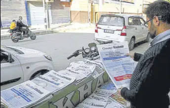  ?? ANI ?? A man reads a newspaper in a closed market in Srinagar on Friday.