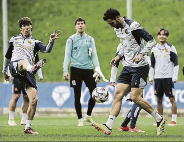  ?? FOTO: RS ?? Mikel Merino da tacadas al balón mientras el resto de jugadores de la Real parece divertirse ayer en Zubieta