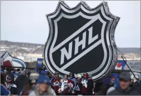  ?? DAVID ZALUBOWSKI - THE ASSOCIATED PRESS ?? FILE - In this Saturday, Feb. 15, 2020, file photo, fans pose below the NHL league logo at a display outside Falcon Stadium before an NHL Stadium Series outdoor hockey game between the Los Angeles Kings and Colorado Avalanche, at Air Force Academy, Colo.