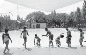  ?? ALGERINA PERNA/BALTIMORE SUN ?? Children wait for lifeguards to give them permission to enter the pool Friday at William McAbee Park in the Sandtown-Winchester neighborho­od in West Baltimore.