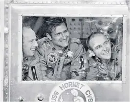  ??  ?? Gordon (centre) and fellow Apollo 12 astronauts inside a quarantine module aboard the USS Hornet