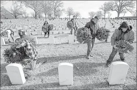  ?? Arkansas Democrat-Gazette/BENJAMIN KRAIN ?? Marine Pfc. Brandon Thorn (front, from left), Staff Sgt. Michael Chalambasa and Staff Sgt. Brooke Chalambasa participat­e in a wreath-laying ceremony Saturday to honor fallen service members at Little Rock National Cemetery. The event coincided with a...