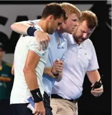  ?? SAEED KHAN/AFP/GETTY IMAGES ?? Grigor Dimitrov, left helps Kyle Edmund walk to the sideline after Edmund fell and injured his right ankle during their match on Friday.