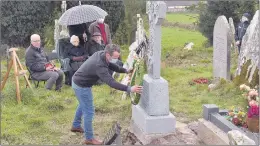  ??  ?? Brian Twomey placing the wreath on his great granduncle, Maurice Galvin’s grave at Dangan Cemetery last Friday.