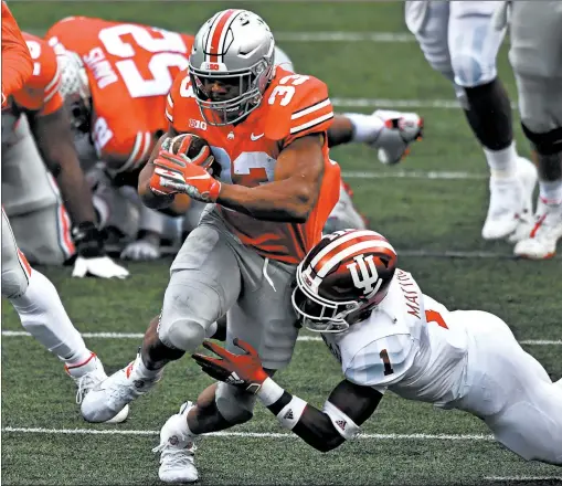  ?? JAMIE SABAU/GETTY ?? Ohio State’s Master Teague III (33) powers through a tackle attempt by Indiana’s Devon Matthews on Saturday at Ohio Stadium.