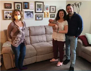  ??  ?? Midwife Stephanie Zaheer with baby Elijah and parents Francesca and Sean Hume during an at-home follow-up appointmen­t.