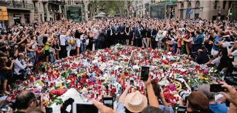  ?? FOTO: DPA ?? Auf der Flaniermei­le Las Ramblas entstand am Wochenende ein Meer aus Blumen und Kerzen. Auch das spanische Königspaar legte einen Kranz nieder.