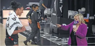  ?? PHELAN M. EBENHACK/ AP ?? Las Vegas Aces center A’ja Wilson is interviewe­d by ESPN reporter Holly Rowe from a safe distance.