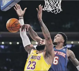  ?? Photograph­s by Kathy Willens Associated Press ?? THE KNICKS’ Elfrid Payton (6) blocks a shot by the Lakers’ LeBron James at Madison Square Garden. James had 21 points in the Lakers’ victory.