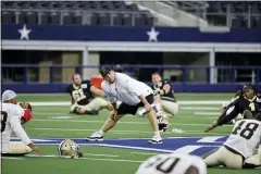  ?? MICHAEL AINSWORTH — THE ASSOCIATED PRESS ?? New Orleans Saints head coach Sean Payton, center, stands on the field as his team stretches as they prepare for an NFL football workout in Arlington, Texas, Monday. Displaced by Hurricane Ida, the Saints went back to work Monday about 500 miles away in the home of another NFL team.