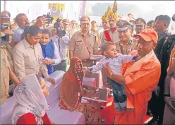 ??  ?? Chief minister Yogi Adityanath holds the son of martyred constable Ankit Tomar during the Police ▪Commemorat­ion Day.