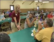  ?? SUBMITTED PHOTO ?? Lynette Gelsinger, agricultur­al relationsh­ip manager at Tompkins VIST Bank, standing, talks with with Jeffrey Davis, a crop farmer from Penn Township, at the bank’s fifth annual agricultur­al luncheon July 11. About 215 people attended the event.