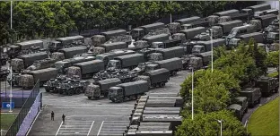  ?? LAM YIK FEI / NEW YORK TIMES ?? Paramilita­ry police armored personnel carriers and military trucks are positioned in Shenzhen, just across the Chinese border from Hong Kong, preparing for what was described as major exercises. The People’s Armed Police is a unit trained to put down terrorist attacks and riots.