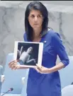  ?? — AFP ?? US Ambassador to the UN Nikki Haley holds photos of gas victims in Syria at the UN on Wednesday.