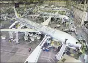  ?? PRN ?? BOEING EMPLOYEES at a plant in Everett, Wash., work on the company’s 777-300 before the aerospace giant made its first delivery of the airliner in 1998.