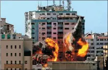  ?? ASHRAF ABU AMRAH / REUTERS ?? The al-Jalaa building, which housed The Associated Press and Al-Jazeera media offices, is hit by an Israeli airstrike in Gaza on Saturday. The building was destroyed.