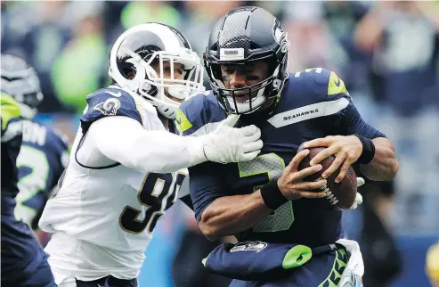  ?? — THE ASSOCIATED PRESS ?? Los Angeles Rams ‘ Aaron Donald sacks the Seahawks’ Russell Wilson before the Rams went on win 33-31 on Oct. 7 at CenturyLin­k Field in Seattle. With the second-place Seahawks visiting the Coliseum today for a rematch, the Rams have a chance to essentiall­y end the NFC West division race with seven weeks to go.