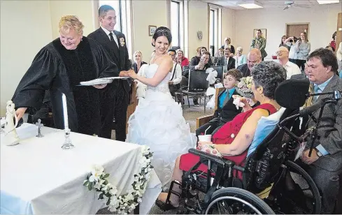  ?? JULIE JOCSAK THE ST. CATHARINES STANDARD ?? Chelsea Barkley and Jordan Harper tie the knot during a small ceremony at Douglas Memorial hospital in Fort Erie where Barkley's ill mother, right in red, Kim Barkley, who is a patient at the hospital, could be present at the wedding.