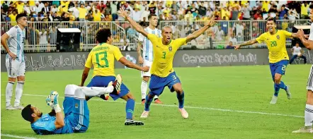  ?? — AFP ?? Miranda (centre, No.3) celebrates after scoring Brazil’s goal against Argentina at the King Abdullah Sport City Stadium in Jeddah.