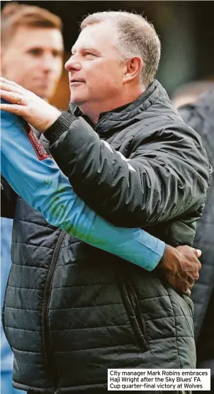  ?? ?? City manager Mark Robins embraces Haji Wright after the Sky Blues’ FA Cup quarter-final victory at Wolves