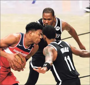  ?? Sarah Stier / Getty Images ?? The Wizards’ Rui Hachimura dribbles the ball as the Nets’ Kyrie Irving (11) and Kevin Durant (7) defend in Sunday’s preseason game.