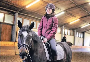  ?? RP-FOTO: STEPHAN KÖHLEN ?? RP-Praktikant­in Jana Huiyue Zhang fasste schnell Zutrauen zu Pferd „Kathan“, auf dem sie mehrere Runden drehte. Zum ersten Mal in ihrem Leben saß sie auf einem Pferderück­en – und genoss es.