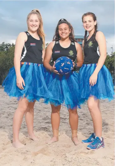  ?? Picture: JUSTIN BRIERTY ?? SAND AND DELIVER: Billie Nolan, 14, Saige Christison, 15, and Courtney Fowler, 14, prepare for Beach Netball on the Cairns Esplanade tomorrow.