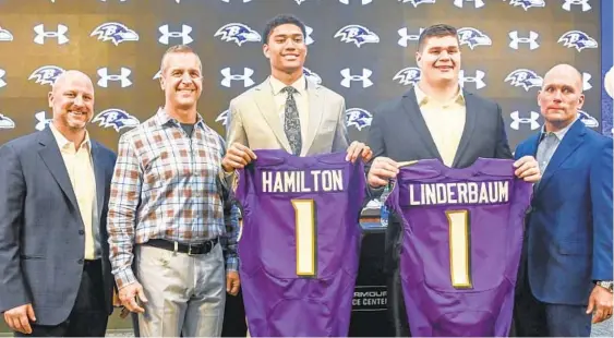  ?? KEVIN RICHARDSON/BALTIMORE SUN ?? Ravens director of player personnel Joe Hortiz, from left, coach John Harbaugh, safety Kyle Hamilton, center Tyler Linderbaum and general manager Eric DeCosta pose for a photo Friday at an introducto­ry news conference for first-round picks Hamilton and Linderbaum.