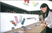  ?? NAN SHAN / FOR CHINA DAILY ?? A visitor looks at a smartphone by Huawei Technologi­es Co Ltd at an internatio­nal telecoms exhibition in Beijing. Huawei sold 139 million handsets in 2016, up 29 percent from the previous year.