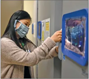  ?? (Arkansas Democrat-Gazette/Stephen Swofford) ?? Hyejin Son, director of pharmacy at Baptist Health Little Rock, on Friday opens one of the new ultra-cold freezers that will store doses of the Pfizer coronaviru­s vaccine. Officials ordered the units in September and received them in mid-November.