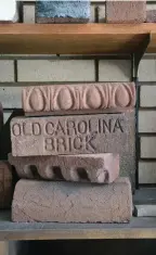  ??  ?? Fabian Bautista prepares to throw a “slug” of clay into a mould on the production line. David Frame, the owner, and Templin Frame, his niece and company sales and marketing rep, with a box of finished Thin Brick. A few of the unique bricks made by Old Carolina, on display in the Salisbury, N.C., showroom. TOP INSET ABOVE