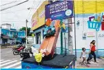  ?? —AFP ?? ESCUINTLA: A woman and her daughter walk by a coffin with a sign reading ‘You decide, at home or in this box’, in the streets of Escuintla municipali­ty, 55 km south of Guatemala City, during a local authoritie­s’ campaign to stop the COVID-19 coronaviru­s pandemic.